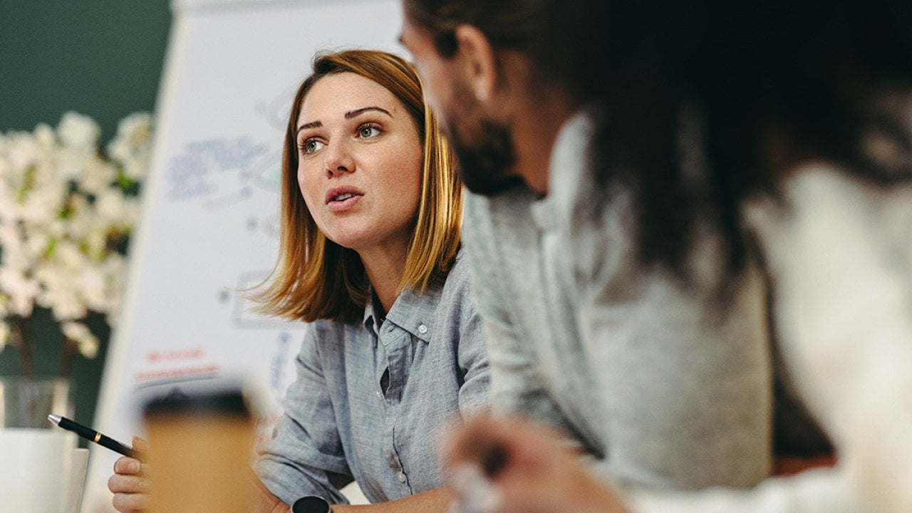 Businesswoman having a discussion with her colleagues in a meeting room.