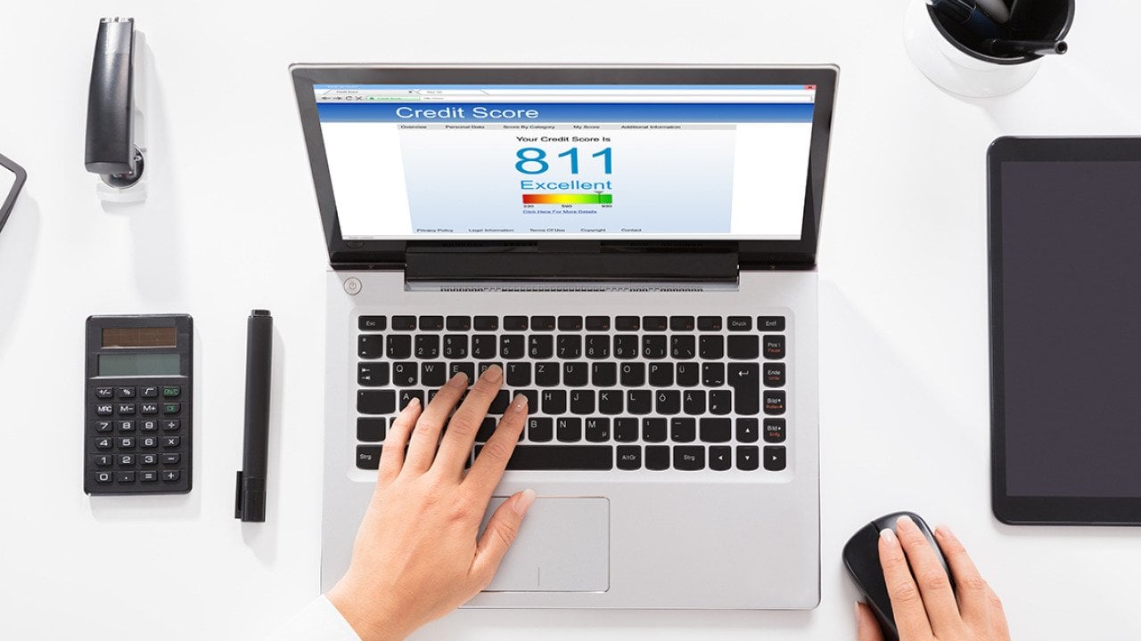 An office table with a laptop showing credit score.