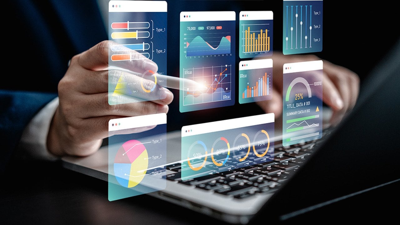 Businessman using a laptop with illustratons of finance software, charts and dashboard graphics.