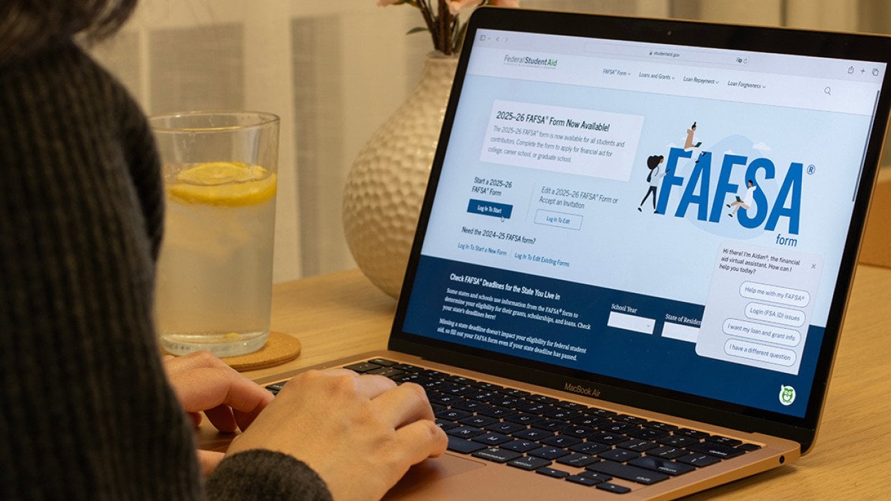 A student browsing the FAFSA website on a laptop.