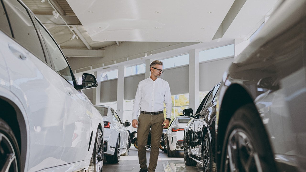 Man looking around a car dealership.
