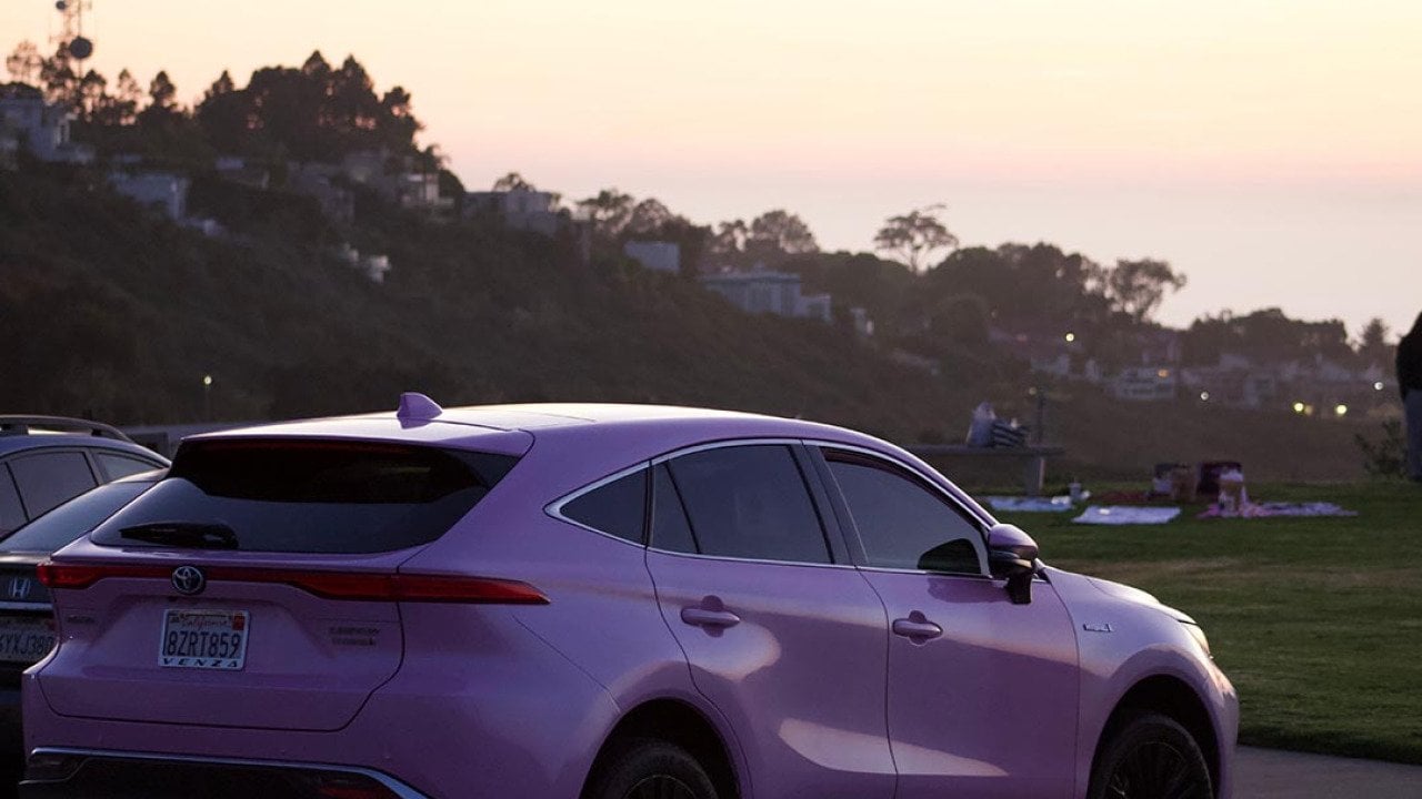 Pink toyota venza that looks lavender parked at mount soledad in san diego during sunset golden hour.
