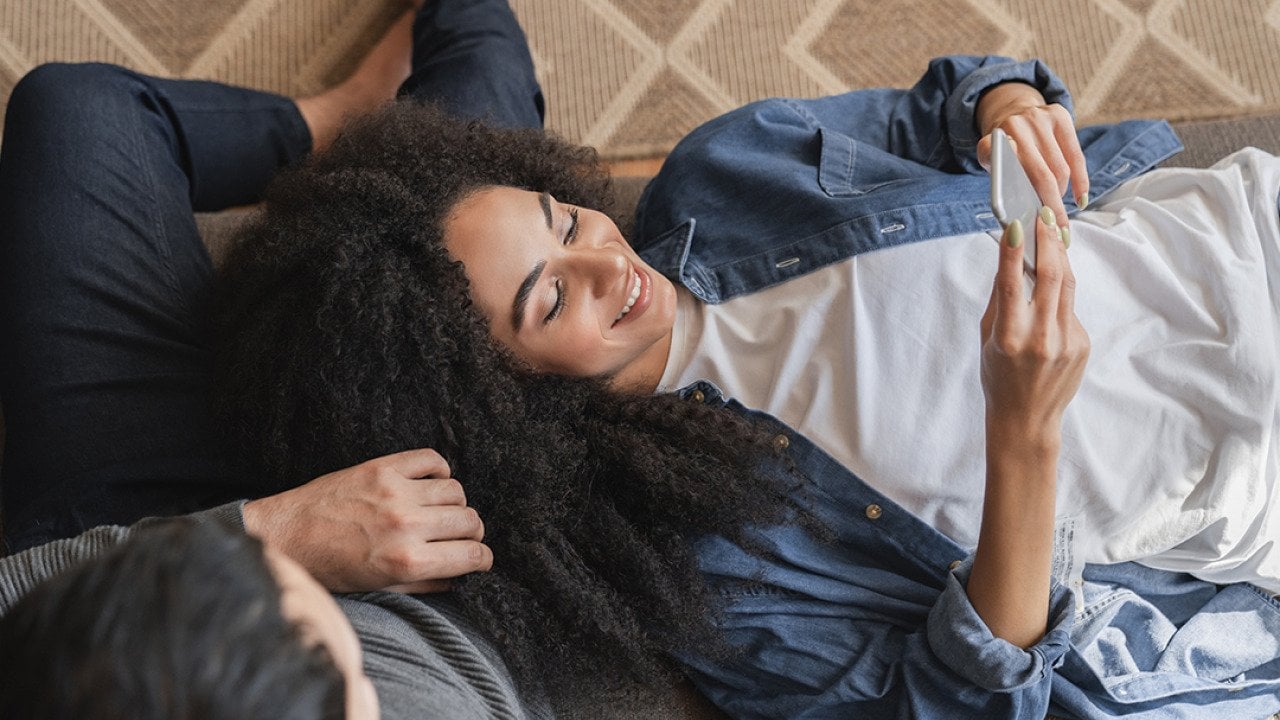Young couple at home browsing information using a phone.