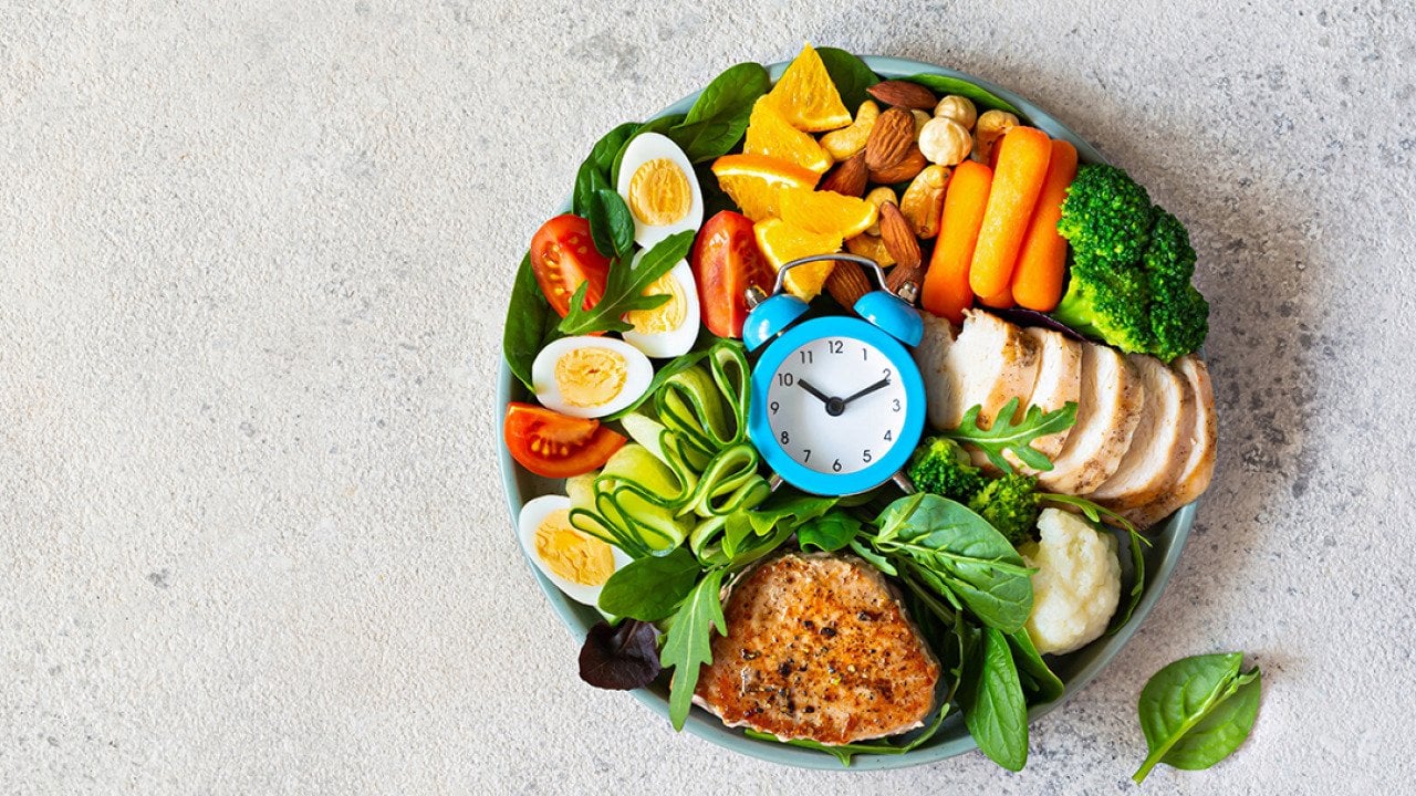 A bowl of vegetable meat with meat, fish, eggs, and a clock at the middle.