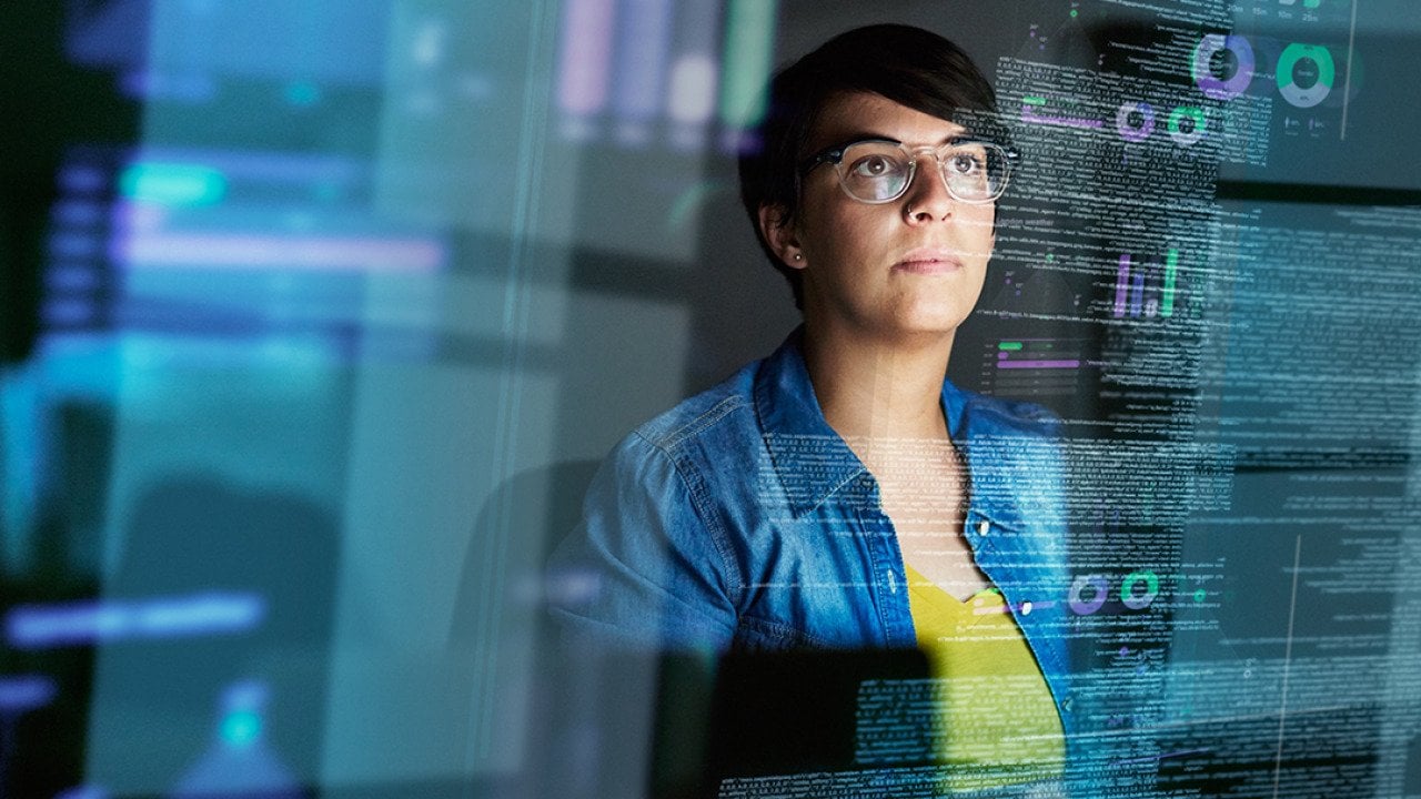 A young female computer programmer looking through data.
