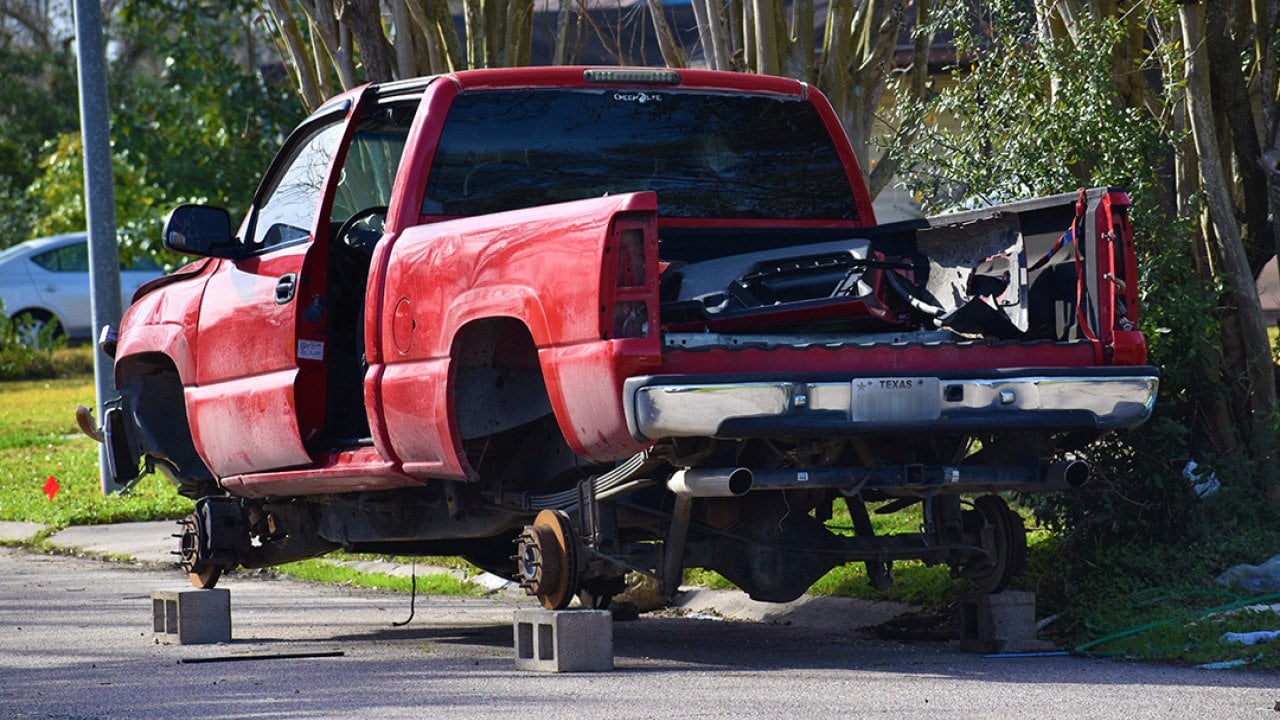A stolen red pick-up truck in Texas, stripped and hoisted with bricks.