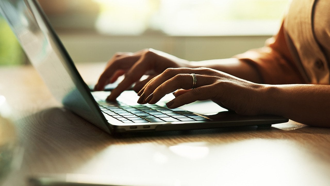 Freelancer typing on a laptop keyboard.
