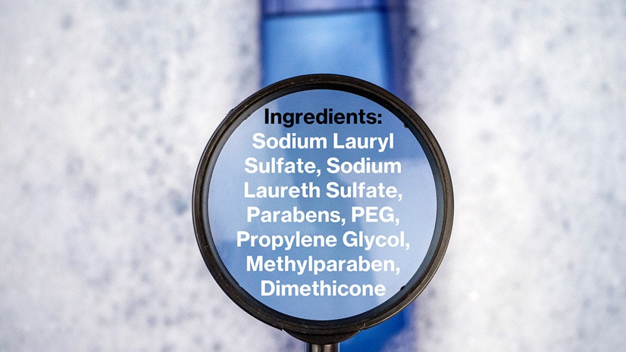 Chemical components listed on a magnifying glass over a shampoo bottle.