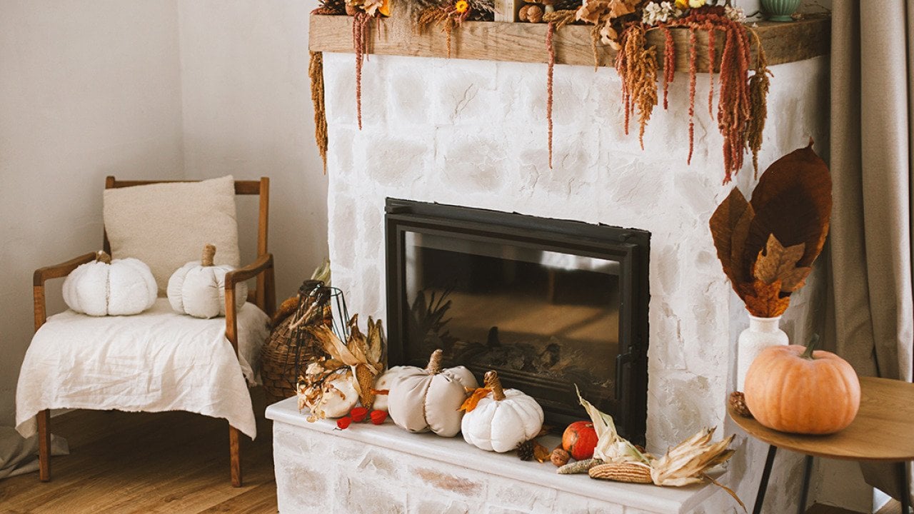 Fireplace corner of a living room with fall season decoration.