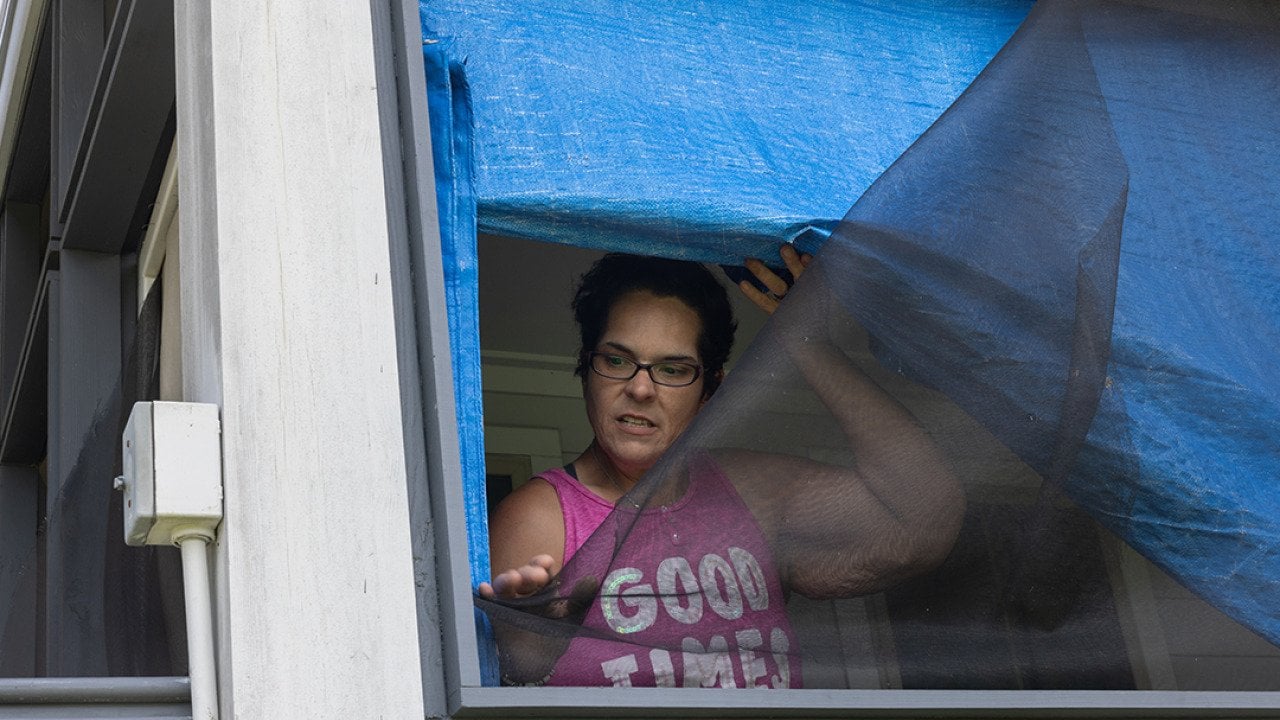 Kristi Naquin shows wind-damaged screens at her 3-year-old home which she says are substandard. They were built as part of the first federally funded relocation project in the United States.