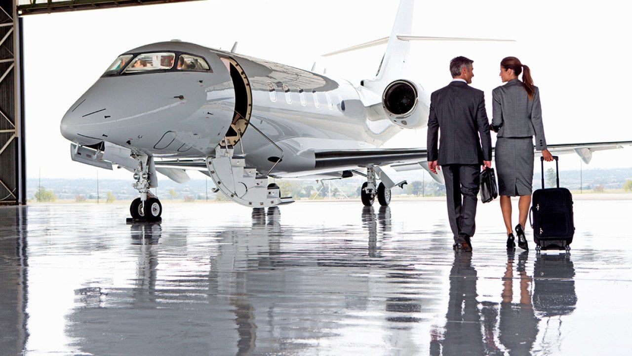A pair of business people walking towards a private plane.