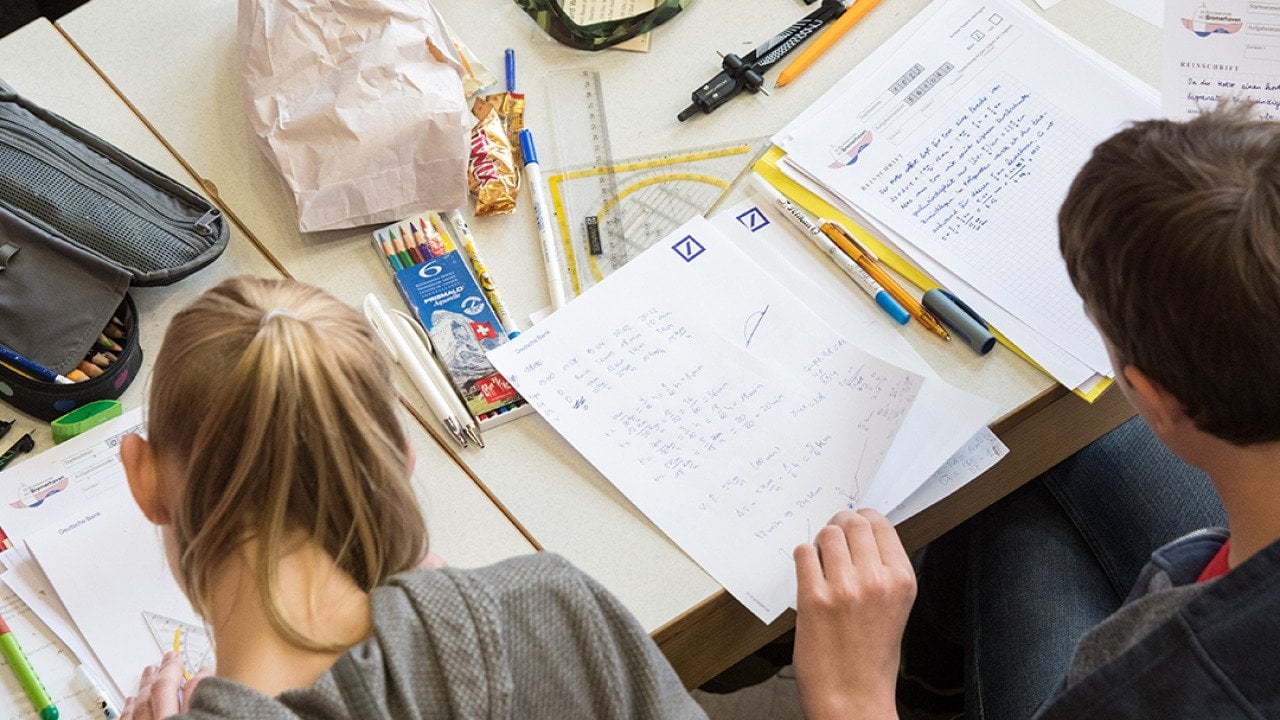 A pair of mathematics students writing on paper during the finals of a math competition.