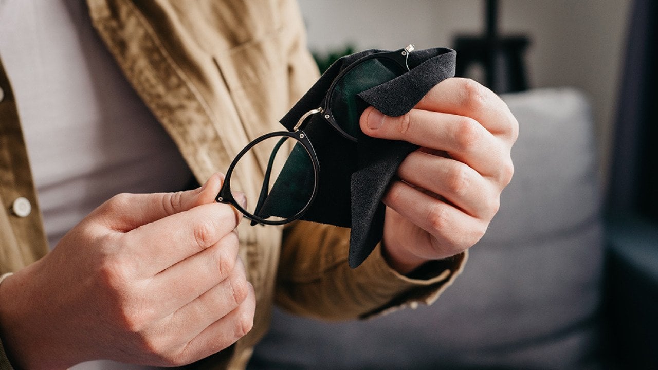 A pair of eyeglasses cleaned with a microfiber cloth.