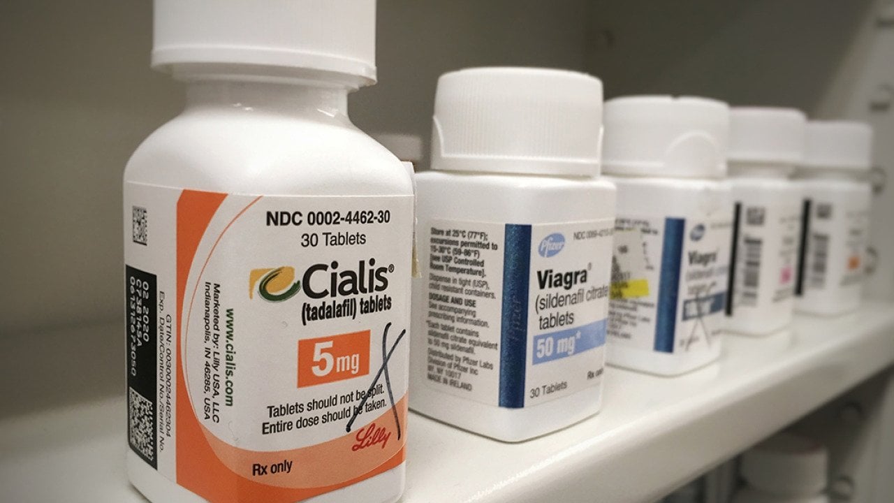 Bottles of Cialis and Viagra on a shelf.