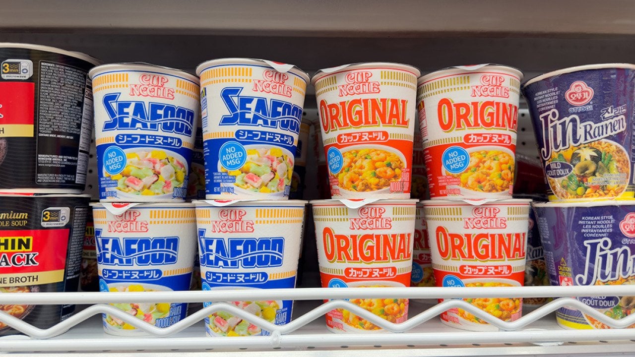 Assorted Cup Noodles packages on a grocery store shelf.