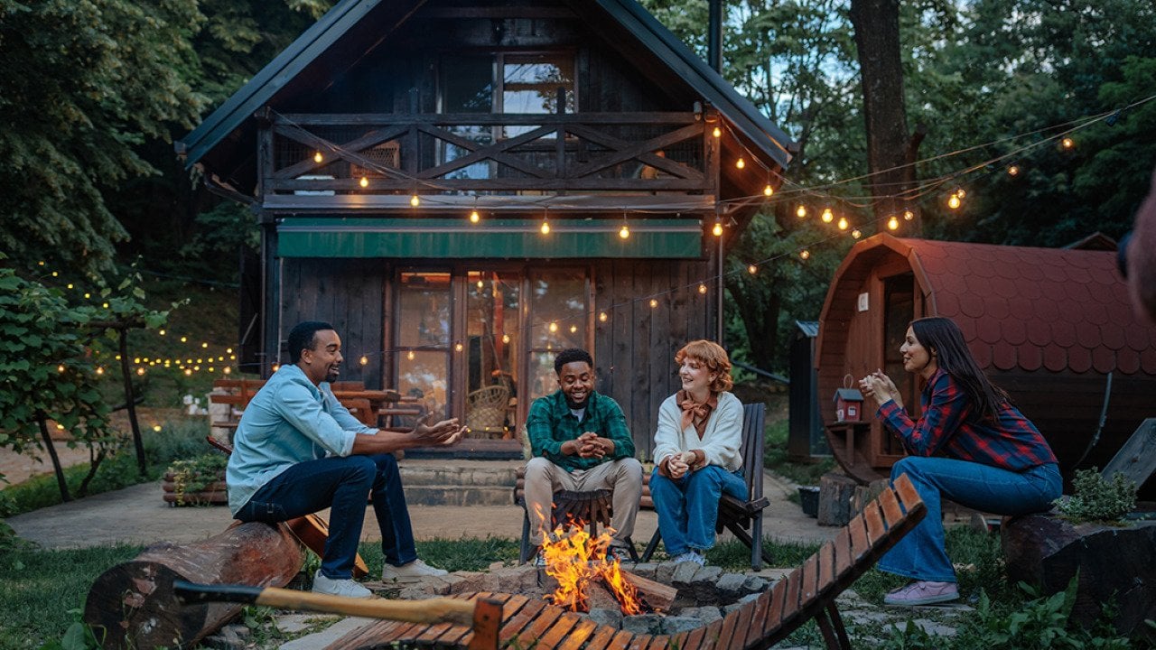 Four people sitting around a fire pit.