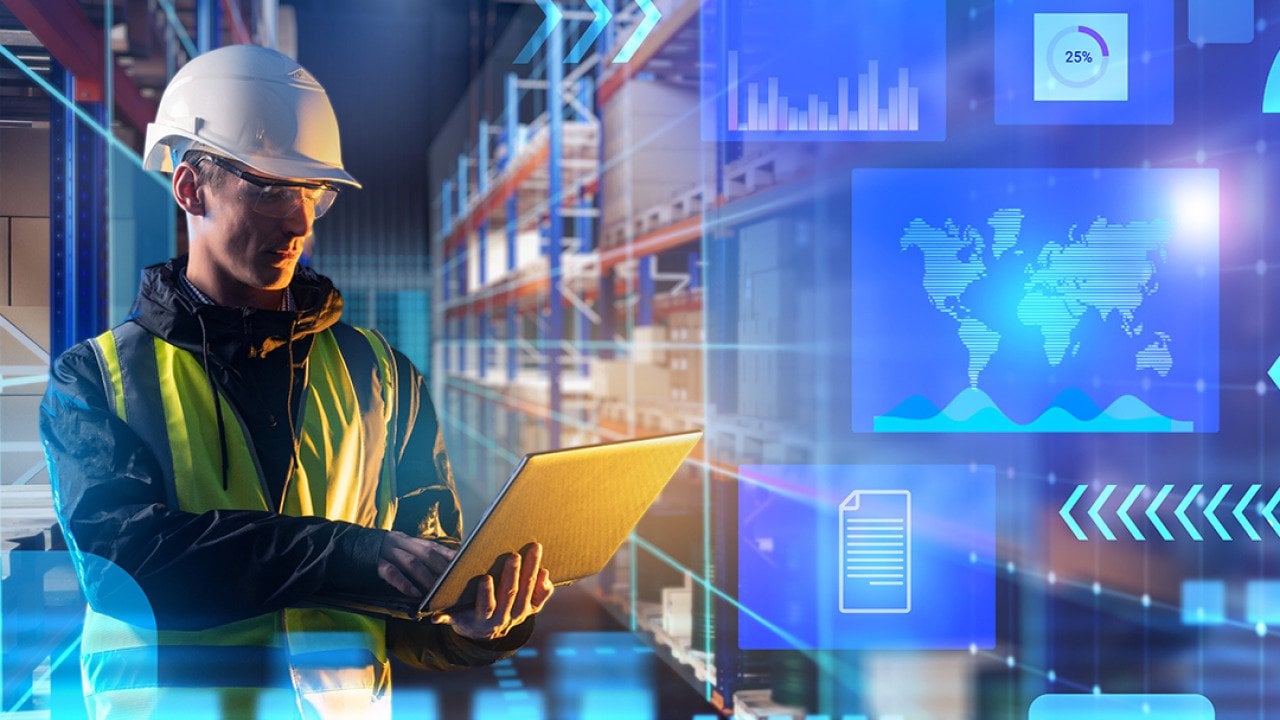 A male worker using laptop in a warehouse with an overlay of technology and logistics graphics.
