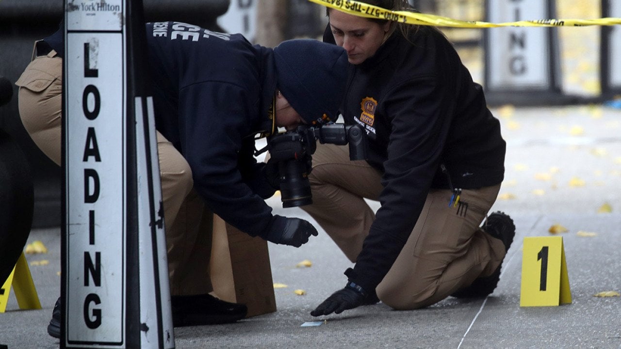 Police take photos as they place bullet casing markers outside of a Hilton Hotel in Midtown Manhattan where United Healthcare CEO Brian Thompson was fatally shot on December 04, 2024 in New York City.
