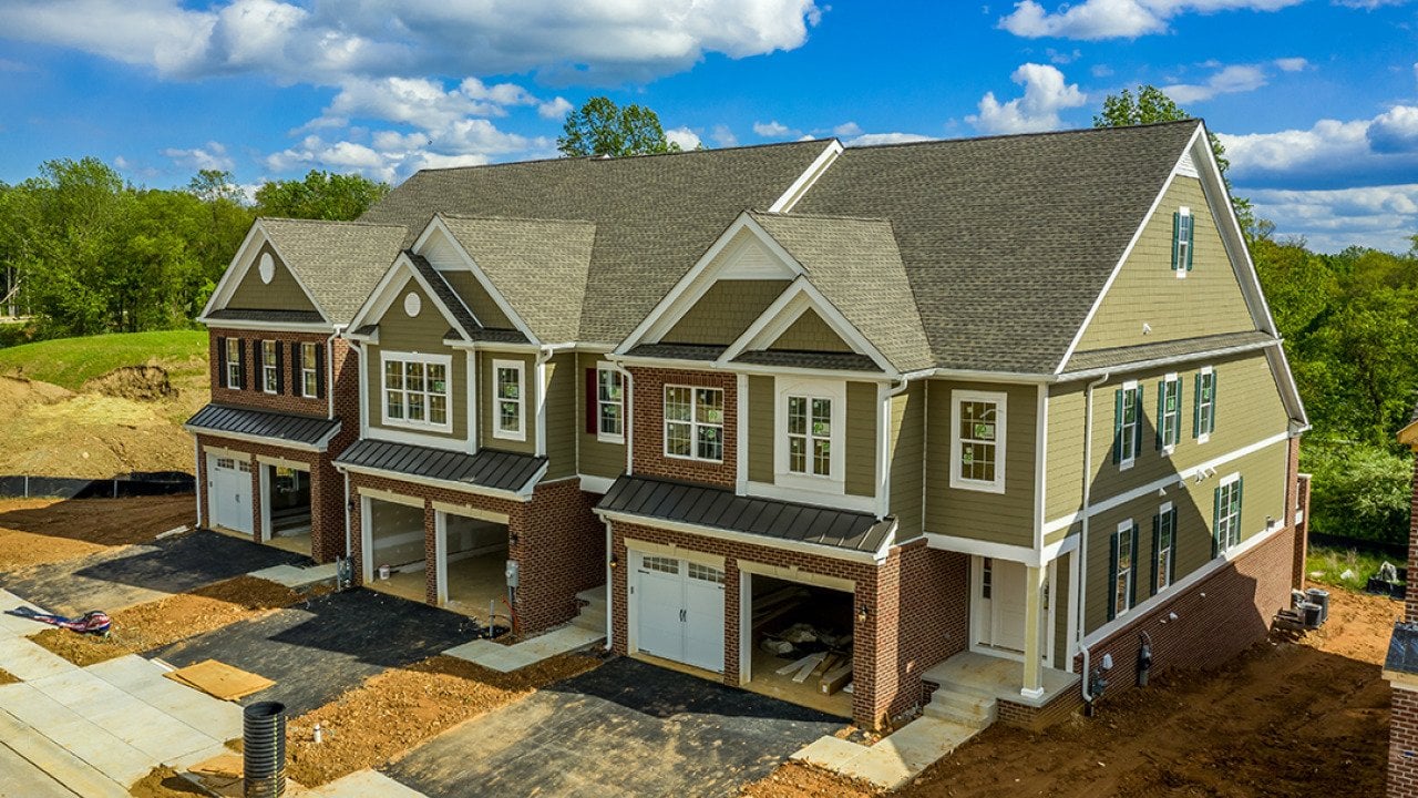 A large, modern triplex home nearing completion.