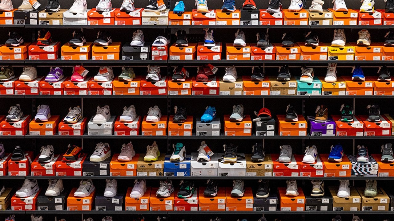 Various styles and models of Nike shoes neatly displayed on store shelves.