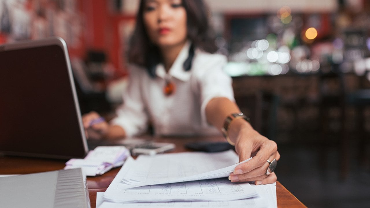 A female business owner reaches out for finance documents.