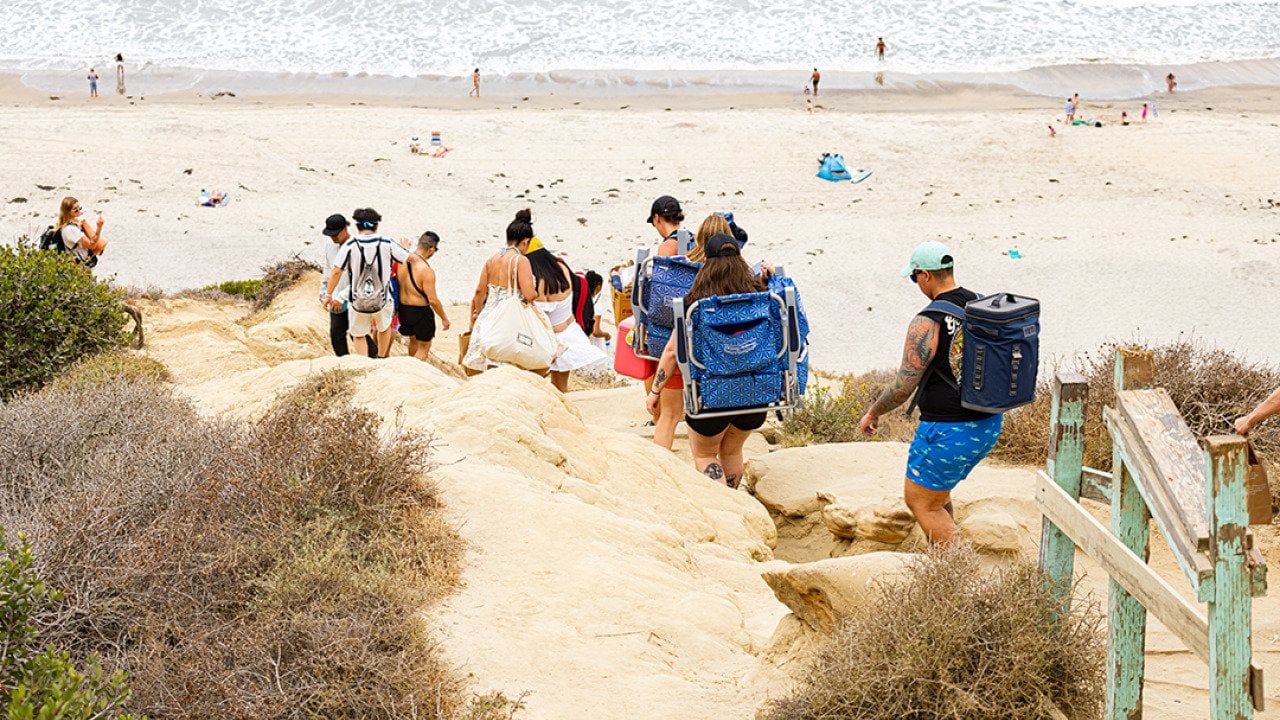 Tourists climb down the Torrey Pines cliffs heading towards Black's Beach in La Jolla in San Diego, California.