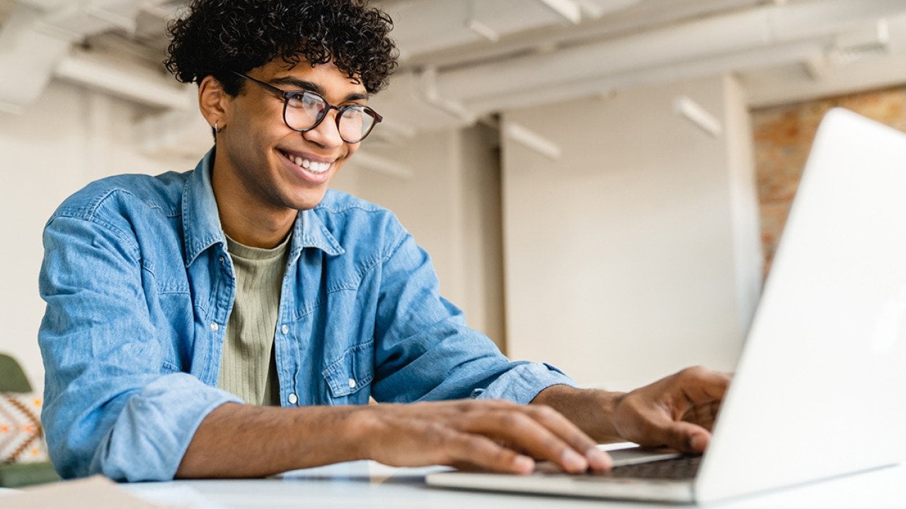A young freelancer using a laptop to work remotely.