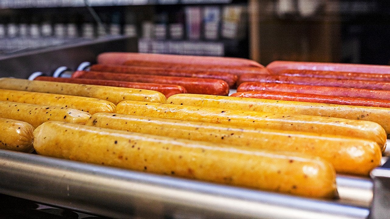 Hot dogs on a roller grill in a gas station.