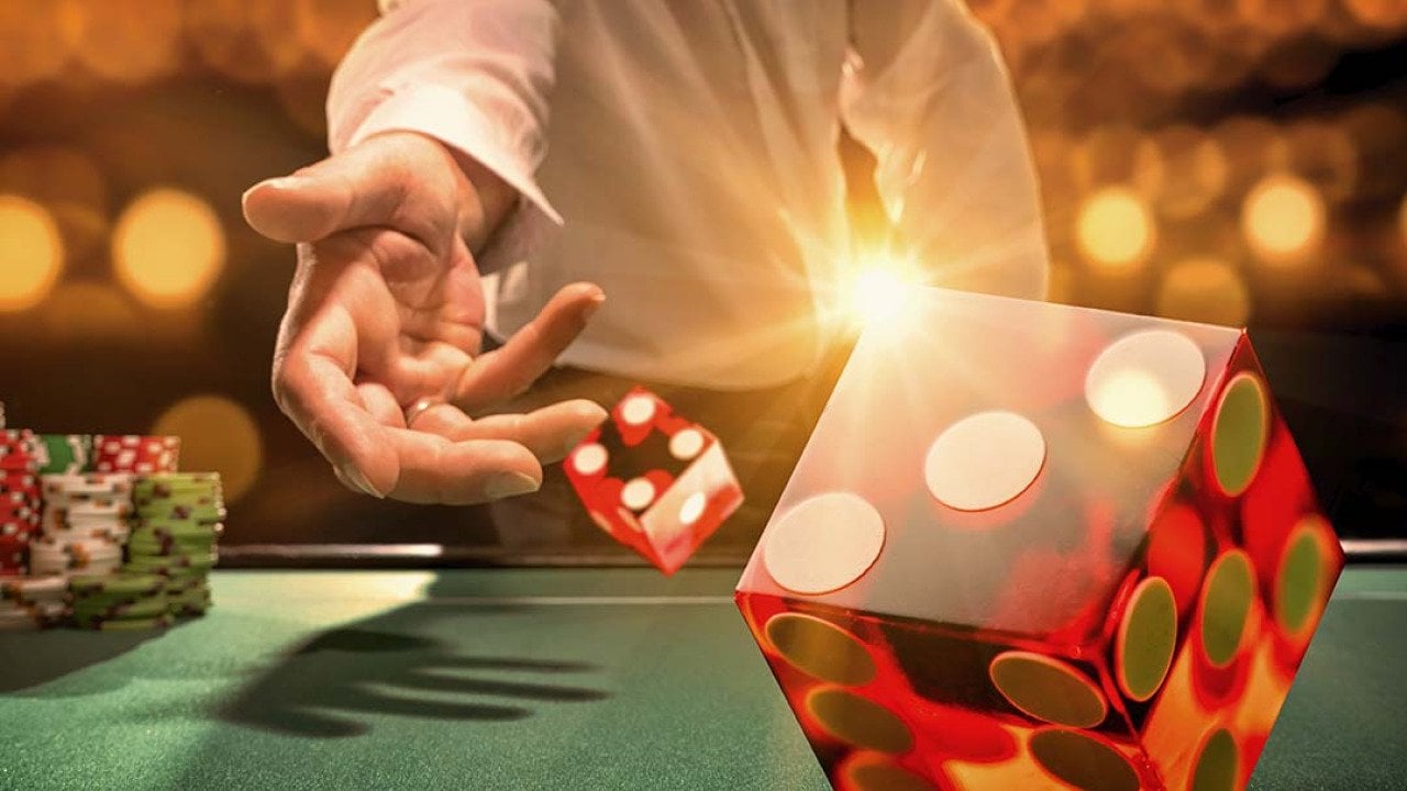 Man throws die at a casino table.