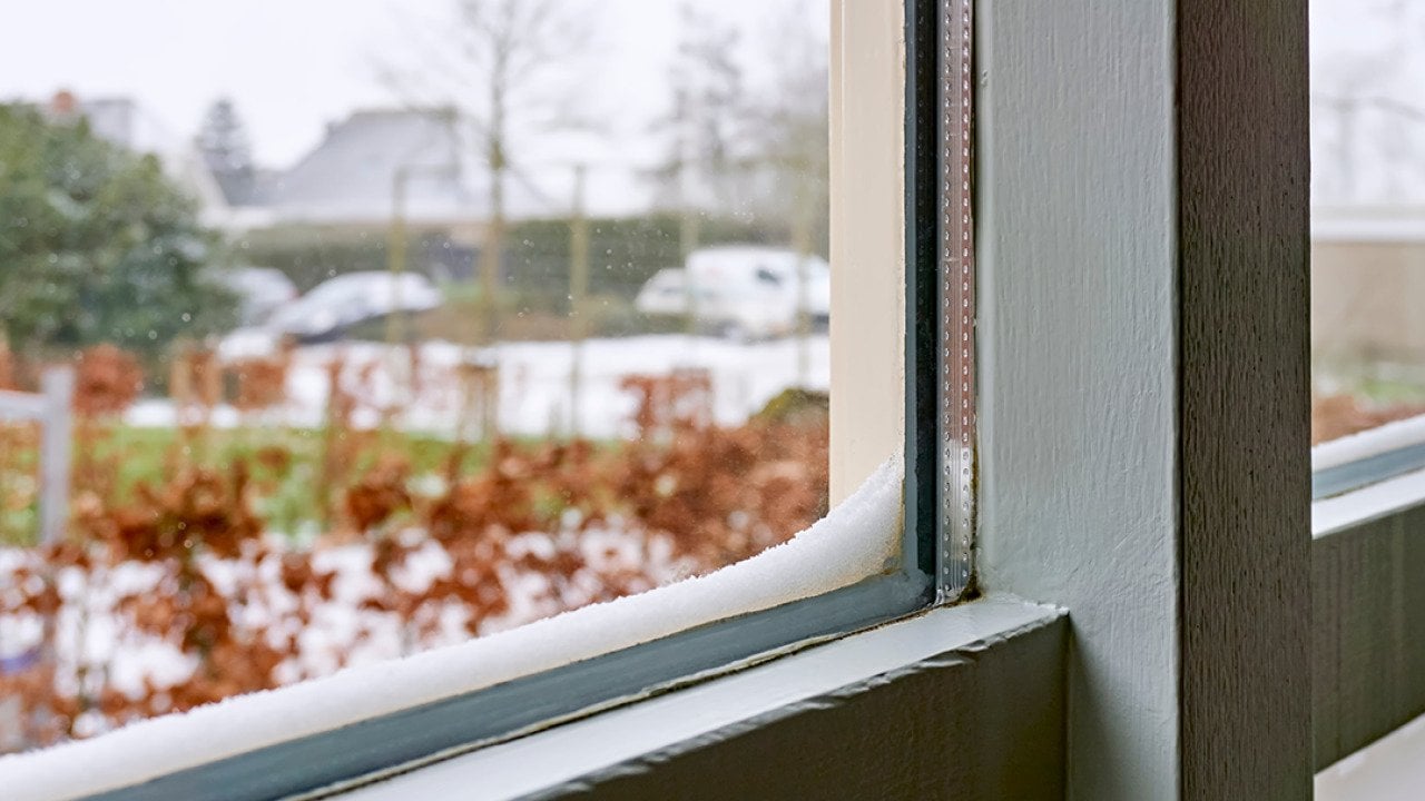 Double-glazed windows with accumulated snow on its edges.