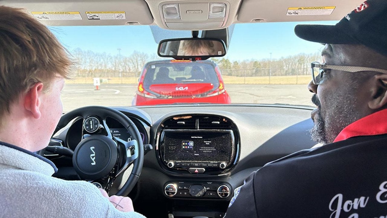 View from backseat of teen driver and expert behind the wheel. 