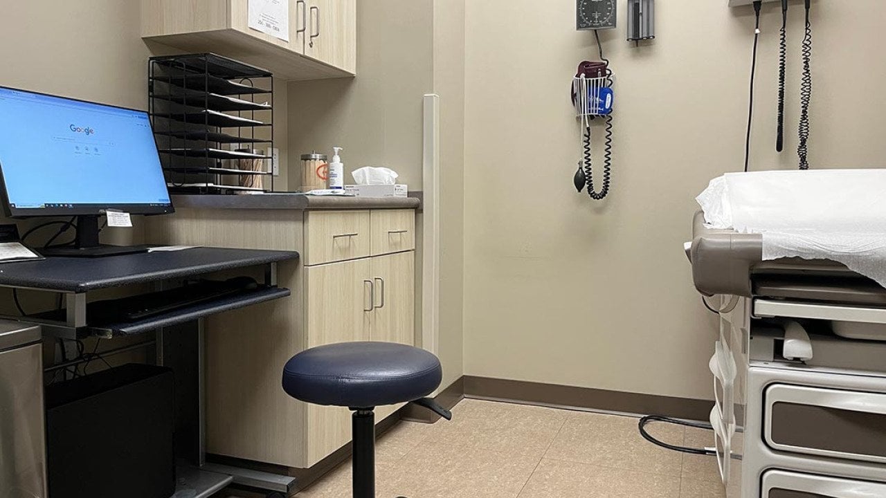 An empty examination room in a clinic with a computer, exam tamble, stool and various medical devices on the wall in Muscle Shoals, Alabama USA.