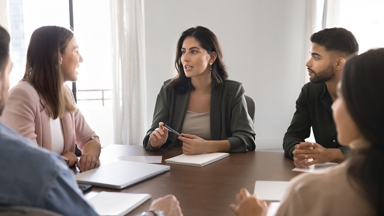 A business team seated around a conference table.