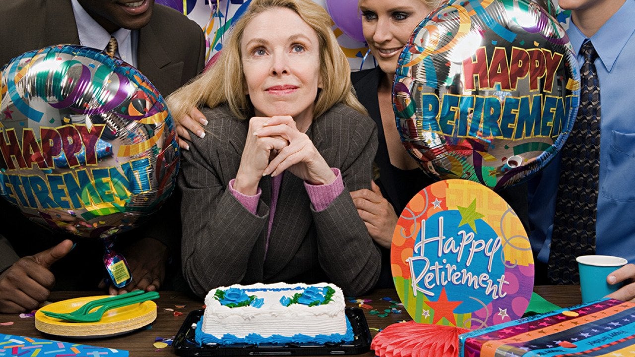 A female employee surrounded by her colleagues during her retirement party.