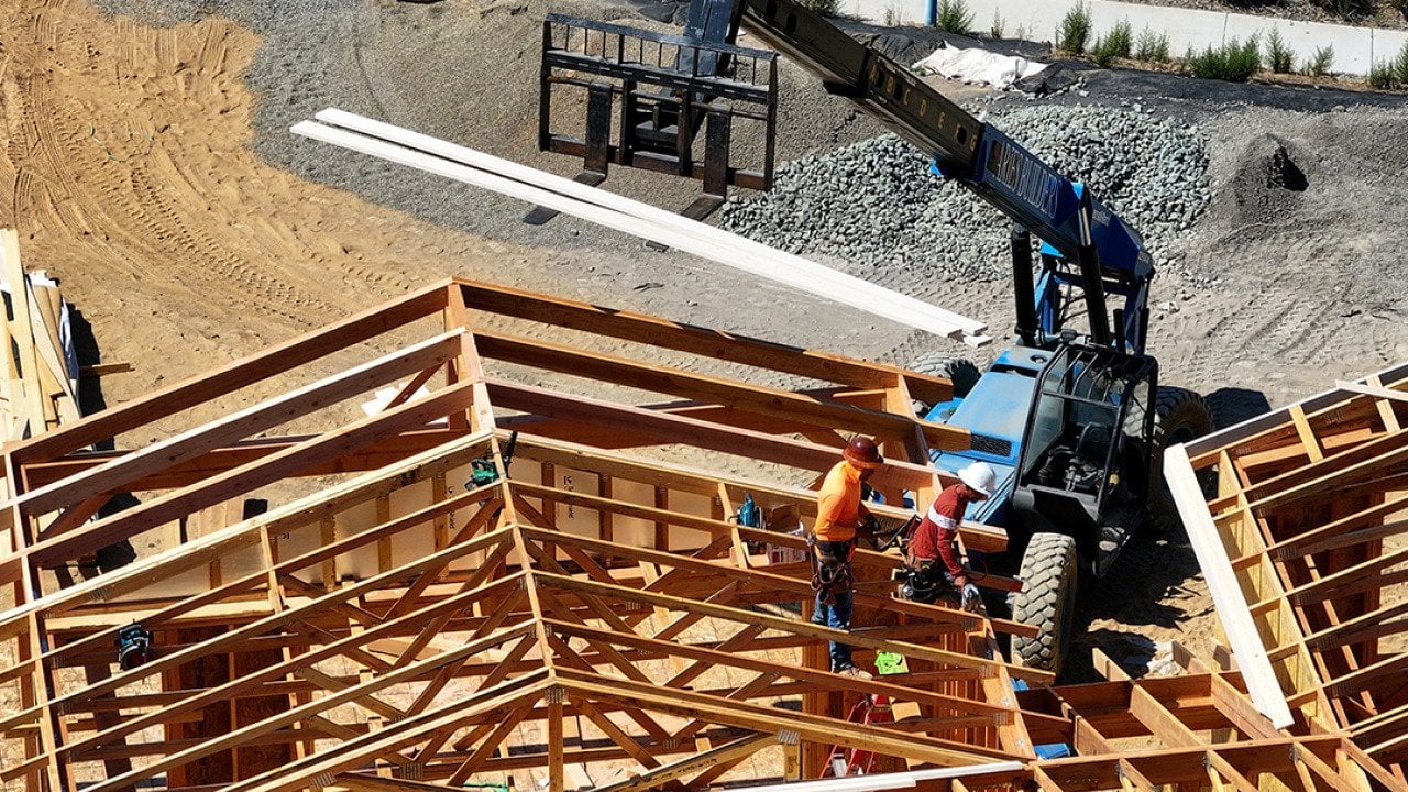 Aerial view of a home under construction with workers present on site in San Rafael, California.