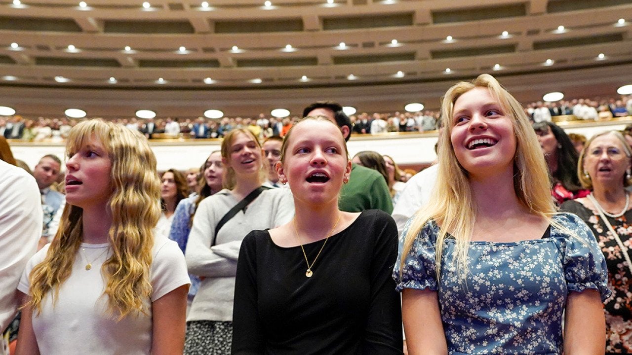 Low angle view of young women singing a hymn during a session of General Conference of The Church of Jesus Christ of Latter-day Saints in April 2025.