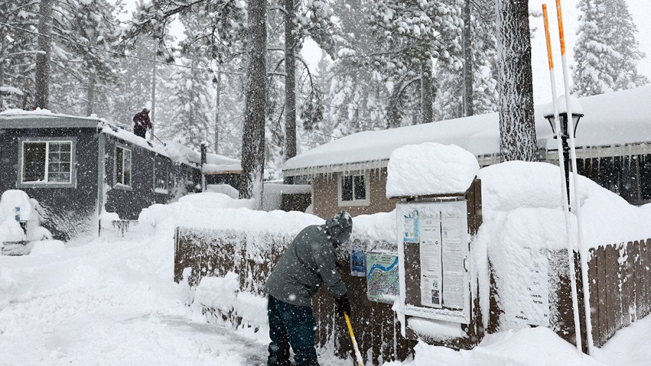 Mobile home owners shovel snow during a winter storm on March 02, 2024 in the Sierra Nevada mountains in Truckee, California.