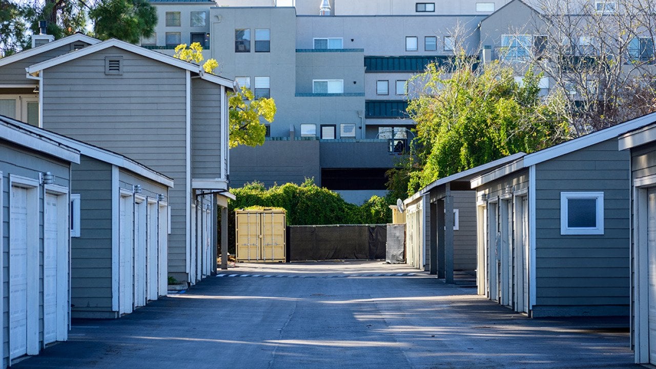 Symmetrical view of urban apartments' garages in a paved driveway.