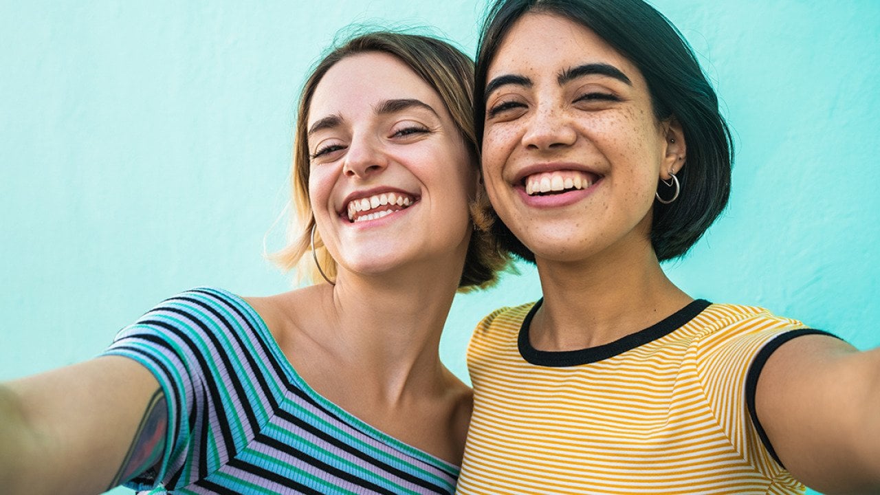 Two young women smiling for a selfie-style photograph.