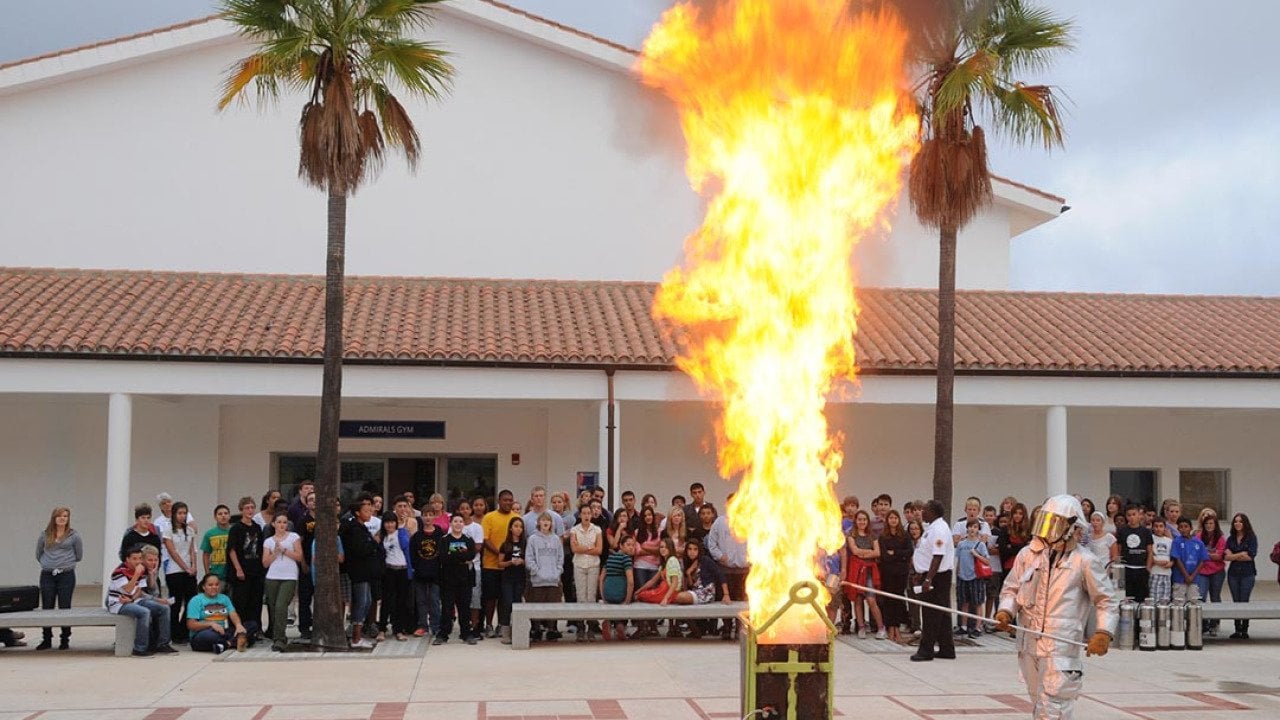 Personnel assigned to the Naval Station Rota Fire Department demonstrate the consequences of putting water on a grease fire to students at David G. Farragut Middle/High School.