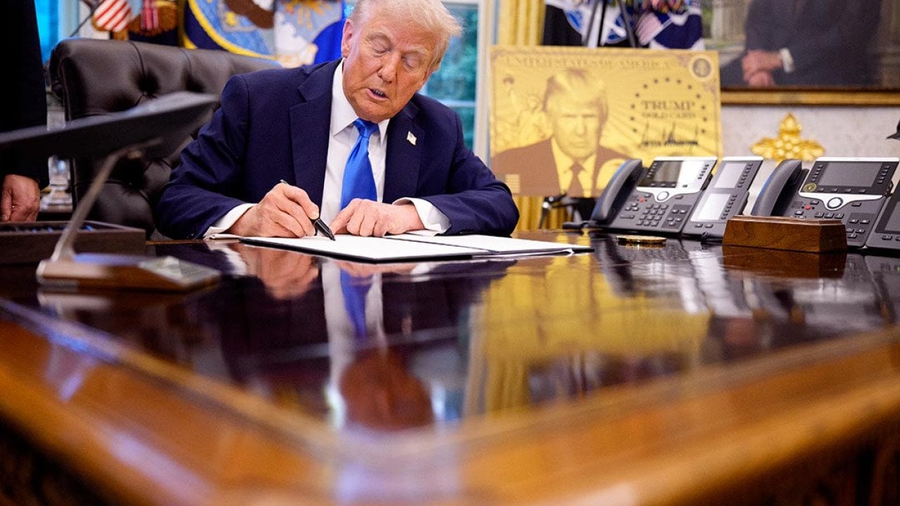 President Donald Trump signs an executive order in the Oval Office at the White House on September 19, 2025 in Washington, DC introducing a $100,000 fee for H-1B visas.