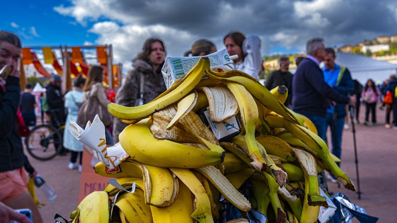 A pile of banana peels in the trash during a marathon in a city.
