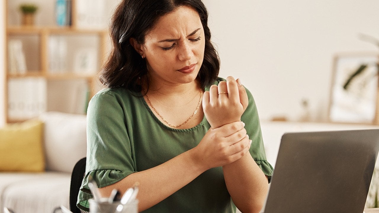 A female employee working from home having wrist aches.