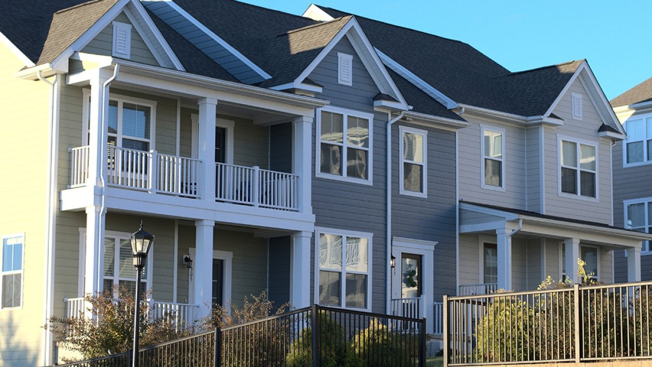 A row of townhouses with grey and white exterior in a housing community.
