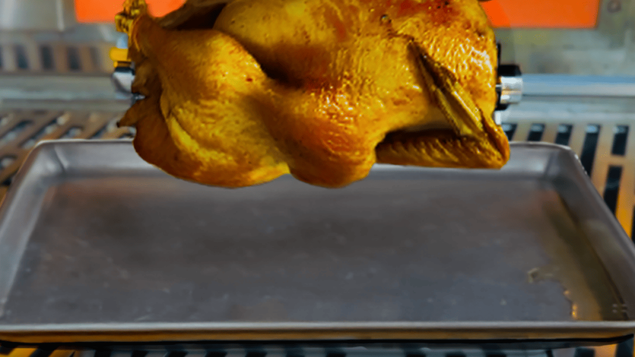 A chicken being roasted in a rotisserie oven.