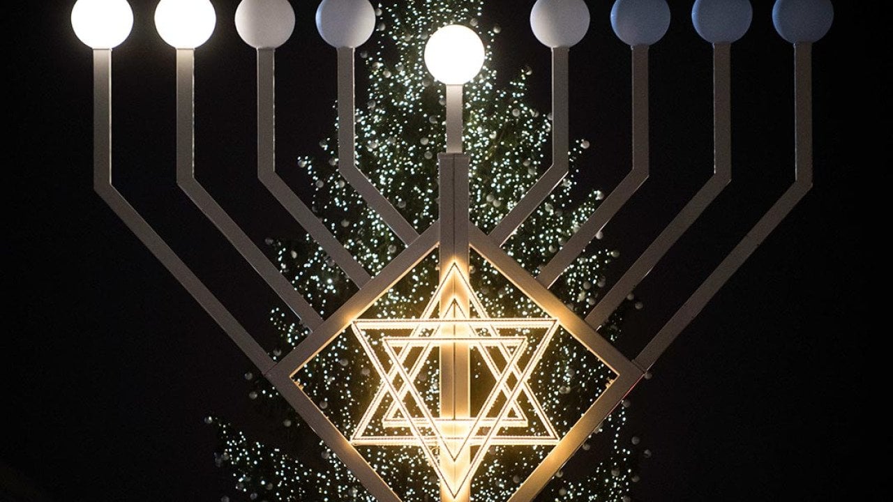 Bulbs symbolizing candles have lit on the 30 foot-tall Hannukah menorah by the Jewish education centre 'Chabad Lubawitsch' in front of a Christmas tree at the Brandenburg Gate in Berlin, Germany.