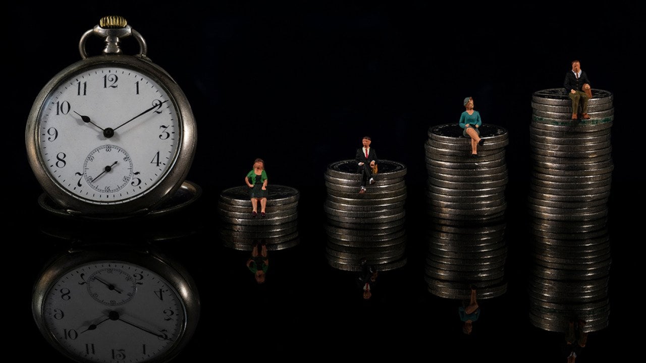 The concept of counting down to retirement illustrated by an increasing stack of coins with miniature people sitting on each one, with a clock placed on the side.