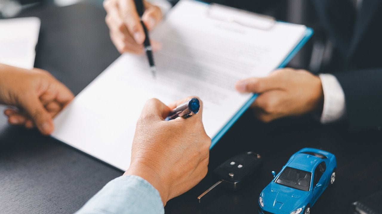 A customer signs a car purchase contract.