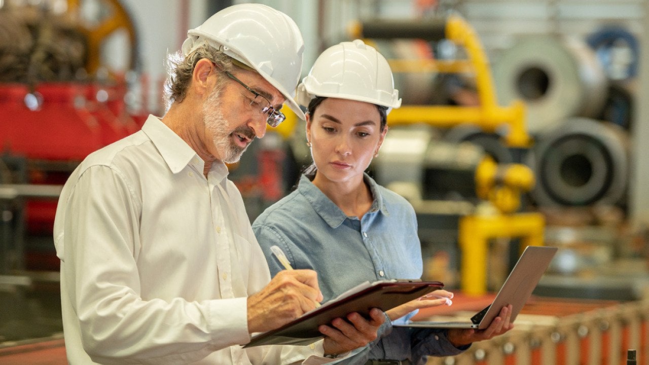 Engineers in an industrial factory conducting machine inspection.
