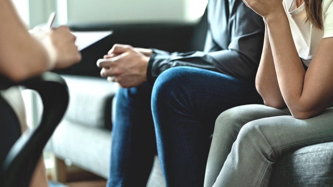 A couple sitting on a sofa during a marriage counseling session.